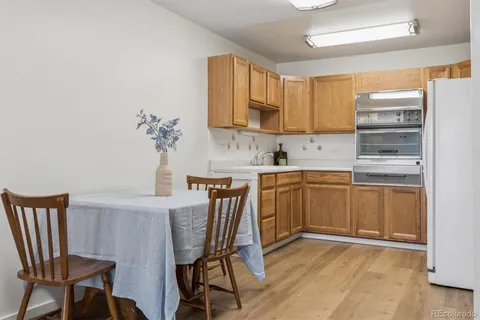 a kitchen with a table chairs refrigerator and microwave