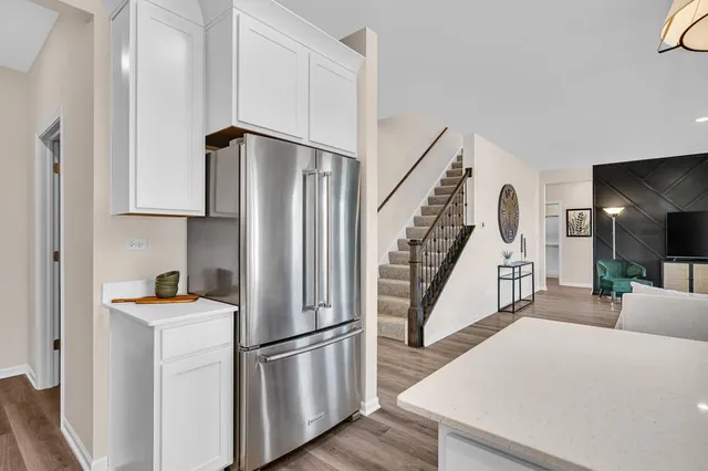 a view of a kitchen with white cabinets and refrigerator