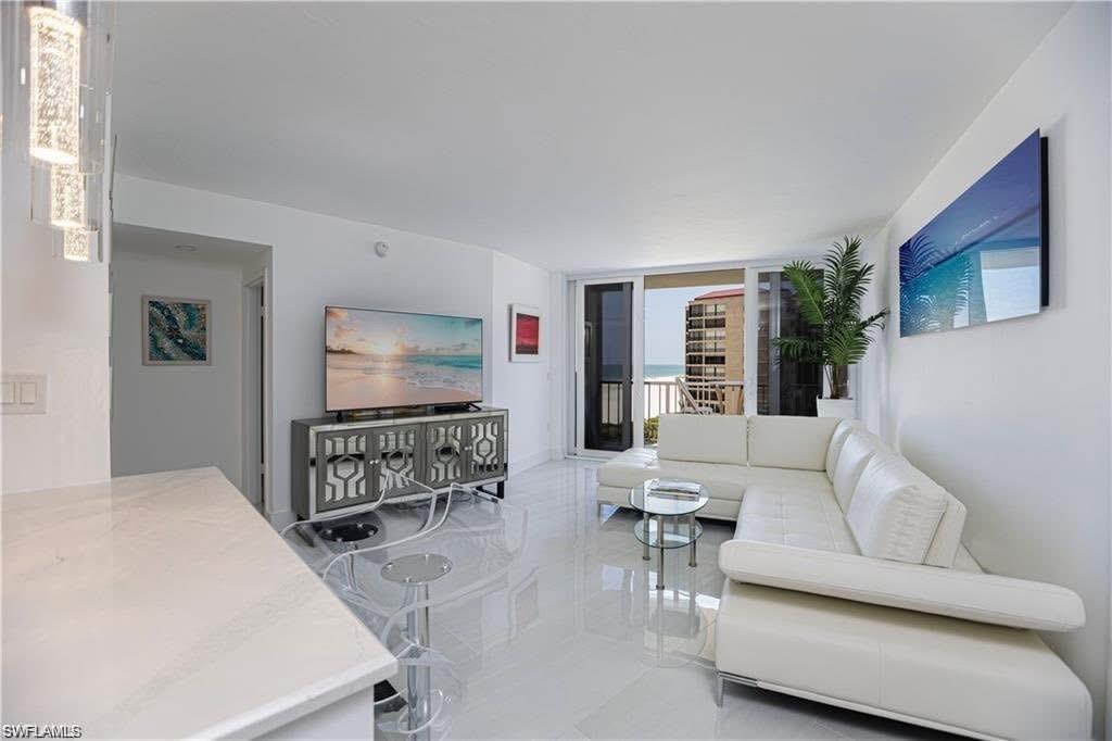 58 North Collier Boulevard, Unit 1010 Marco Island, FL 34145 - Photo 3 of 12 a living room with furniture and a flat screen tv