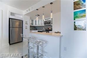 58 North Collier Boulevard, Unit 1010 Marco Island, FL 34145 - Photo 5 of 12 a kitchen with refrigerator and cabinets
