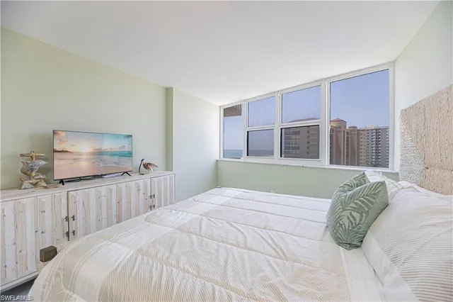 a bedroom with a large bed and a flat screen tv