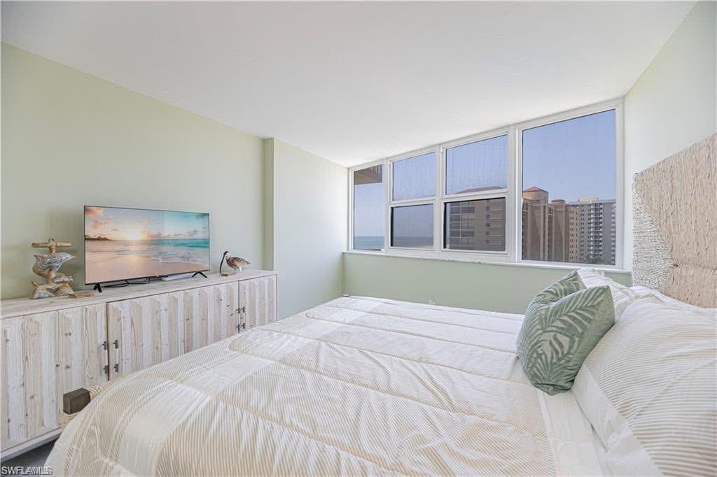 58 North Collier Boulevard, Unit 1010 Marco Island, FL 34145 - Photo 6 of 12 a bedroom with a large bed and a flat screen tv