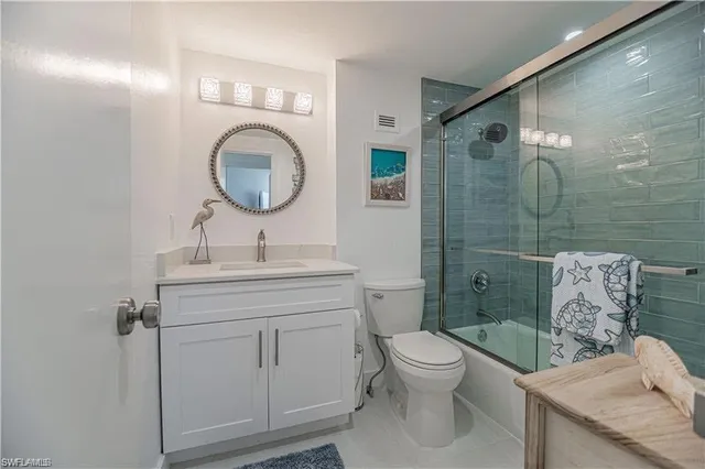 a bathroom with a toilet sink vanity and mirror