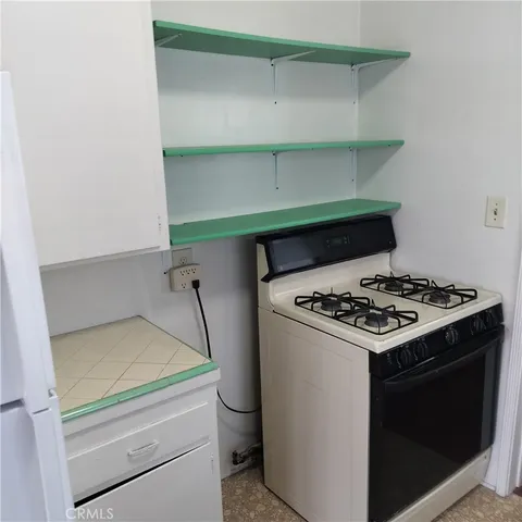 a stove top oven sitting inside of a kitchen