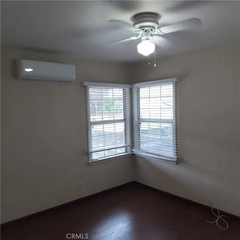 en empty room with windows and ceiling fan