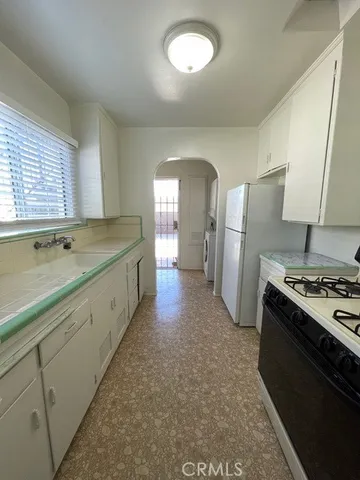 a kitchen with refrigerator a stove and a sink