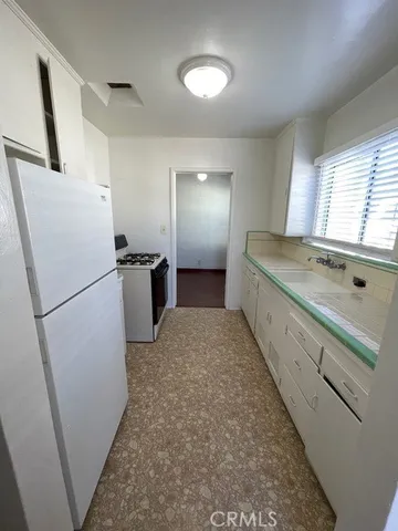 a kitchen with a refrigerator and a sink