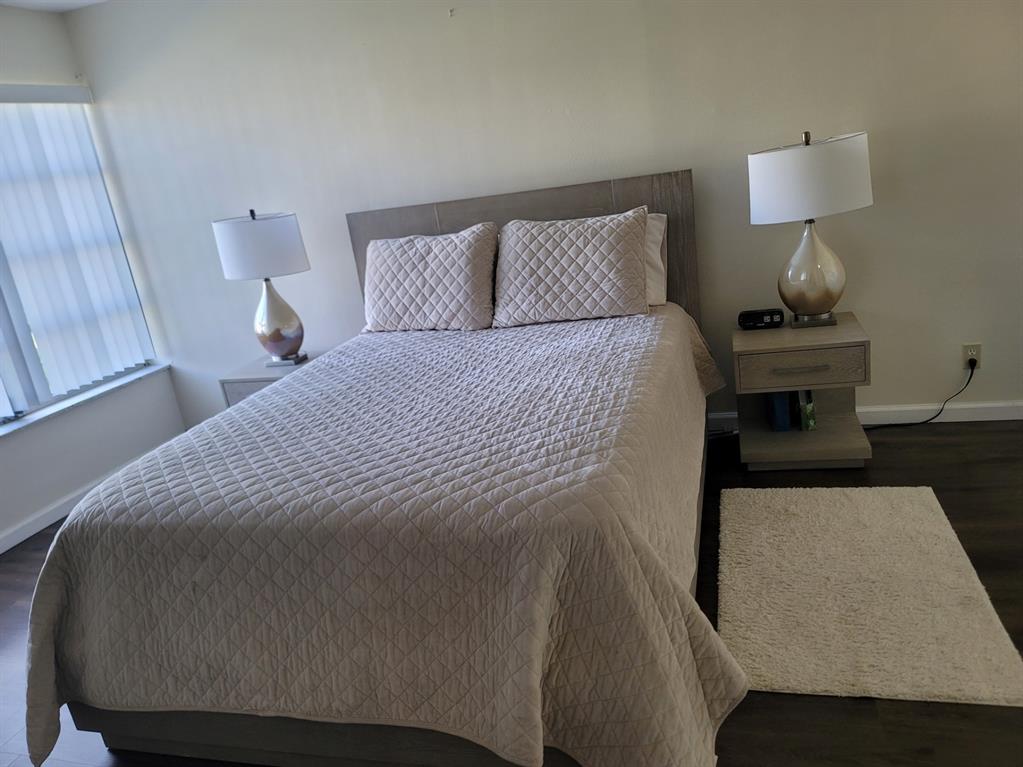 3774 Inverrary Boulevard, Unit P202 Lauderhill, FL 33319 - Photo 19 of 31 a bedroom with a bed and wooden floor