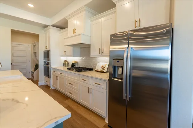 a kitchen with kitchen island a counter top space a sink stainless steel appliances and cabinets
