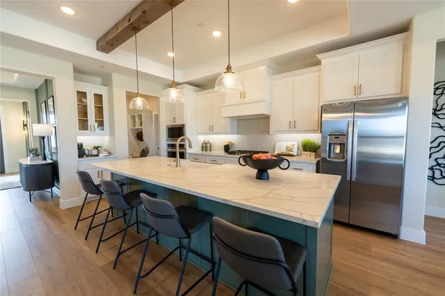 a kitchen with granite countertop a table chairs stainless steel appliances and cabinets