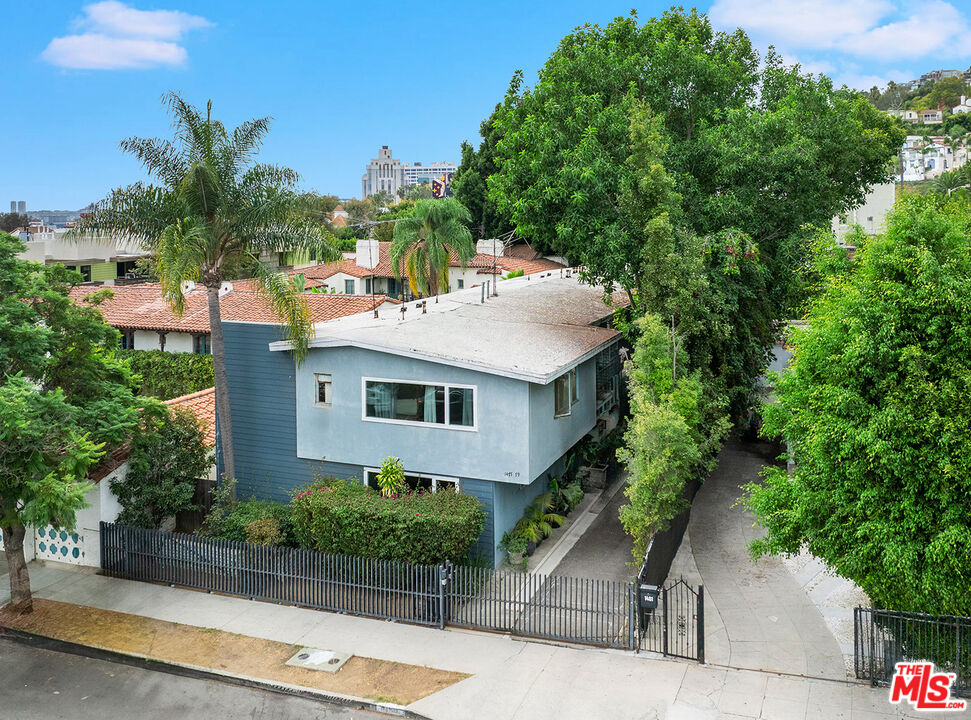 an aerial view of a house with a yard and tree s