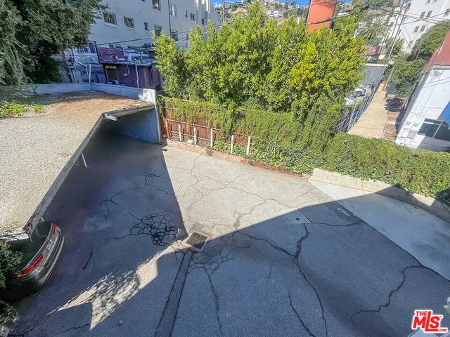 a view of a yard with plants and wooden fence