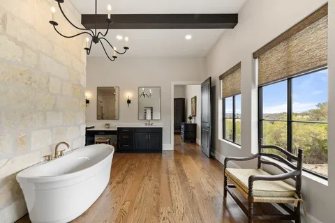 a spacious bathroom with a double vanity sink a mirror and a bathtub