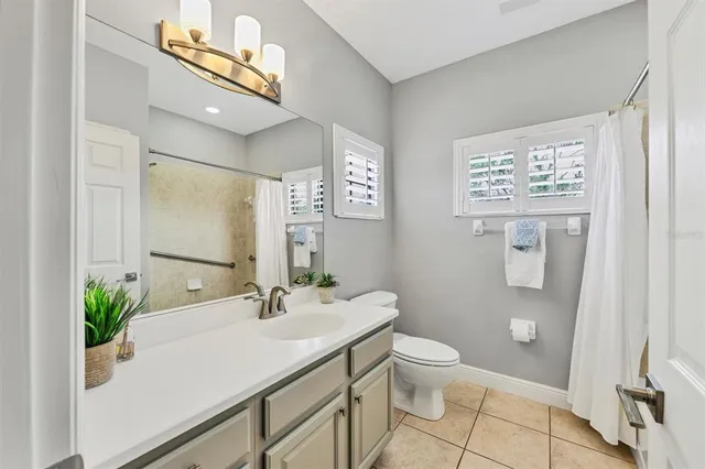 a view of a house with a yard and palm trees