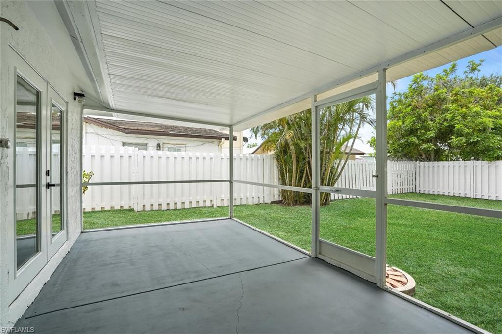 1336 Highlands Drive Naples, FL 34103 - Photo 15 of 17 a view of backyard with large trees and wooden fence