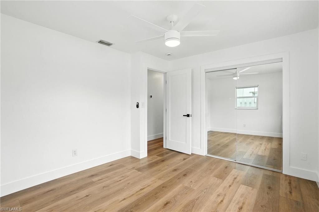 1336 Highlands Drive Naples, FL 34103 - Photo 8 of 17 an empty room with wooden floor and windows