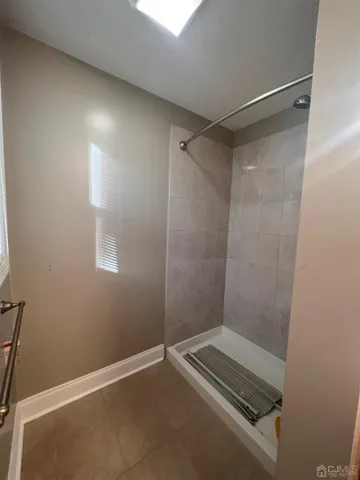 a room with stainless steel appliances kitchen island wooden floors and white cabinets