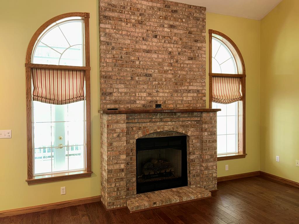 114 Oak Ridge Drive Clarion, PA 16214 - Photo 17 of 38 an empty room with wooden floor a fireplace and windows