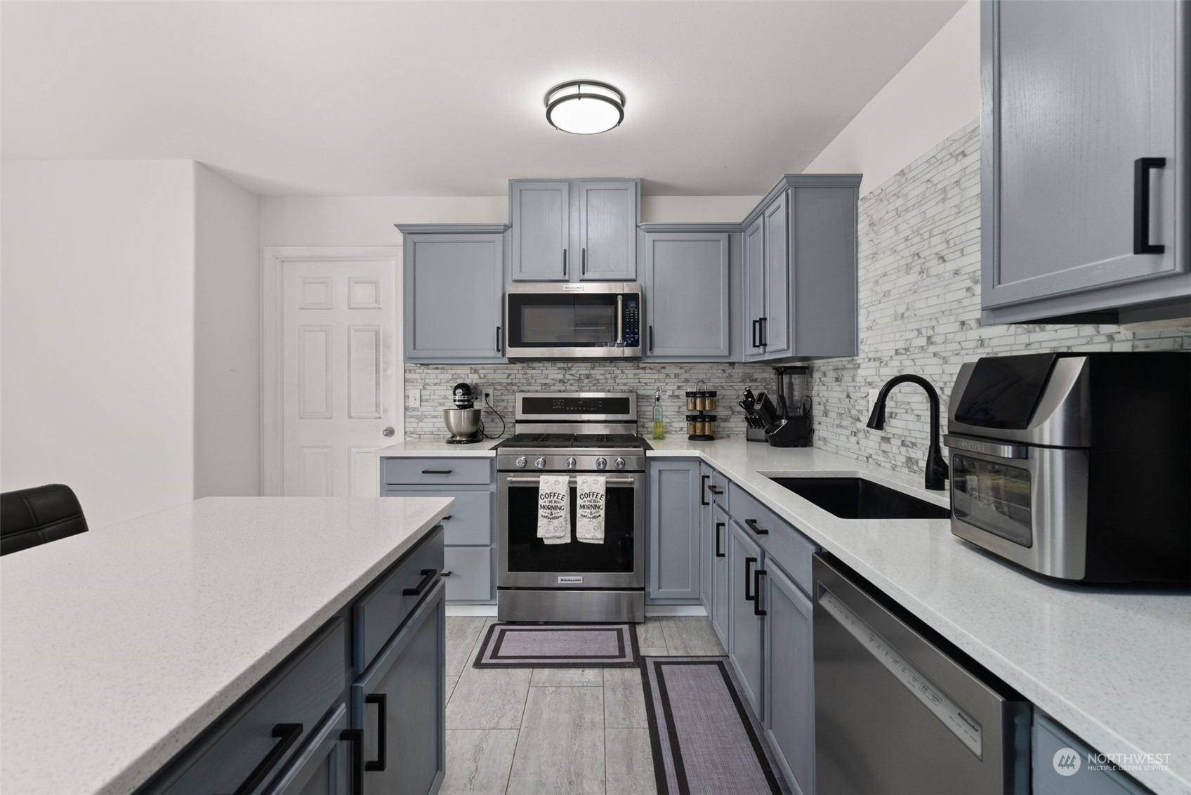 413 Easy Street Rainier, WA 98576 - Photo 5 of 30 a kitchen with stainless steel appliances a stove sink microwave and cabinets