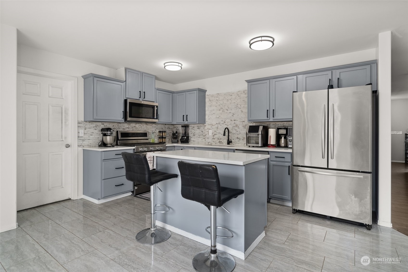 413 Easy Street Rainier, WA 98576 - Photo 6 of 30 a kitchen with cabinets stainless steel appliances and a refrigerator