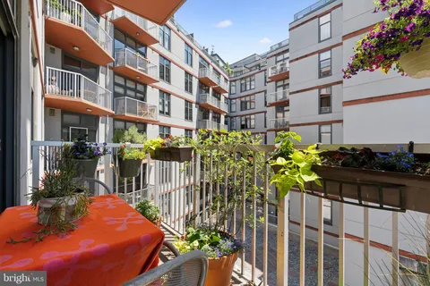 a front view of a house with wooden chairs in patio