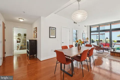 a view of a dining room with furniture a chandelier and wooden floor