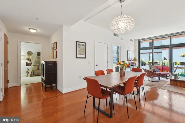a view of a dining room with furniture a chandelier and wooden floor