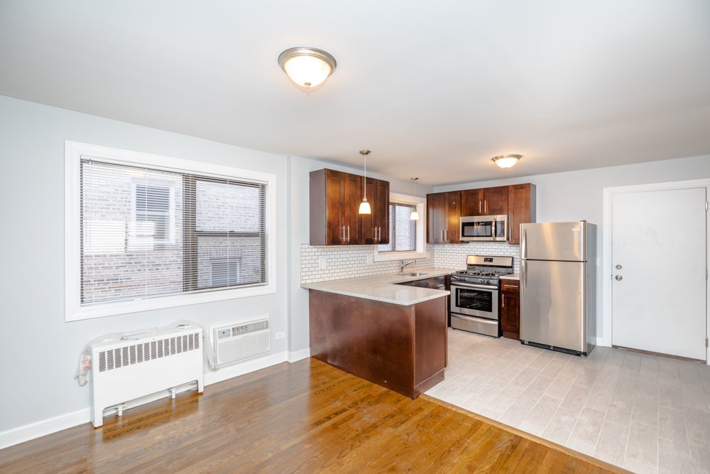 6807 North Ridge Boulevard, Unit 101 Chicago, IL 60645 - Photo 11 of 13 a living room with stainless steel appliances kitchen island granite countertop a stove and a refrigerator