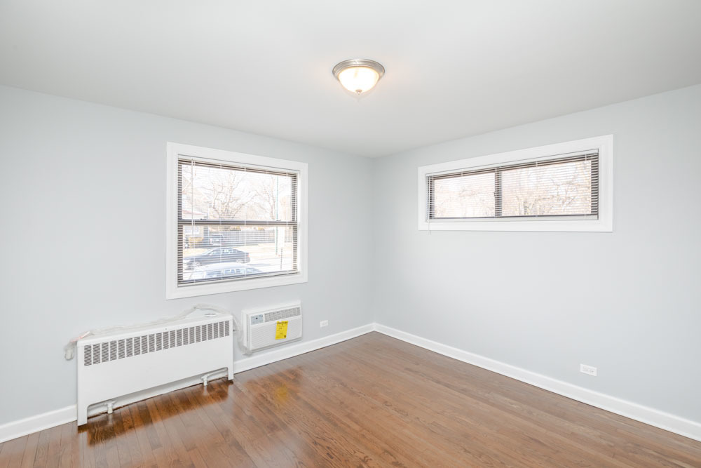 6807 North Ridge Boulevard, Unit 101 Chicago, IL 60645 - Photo 12 of 13 an empty room with wooden floor and windows