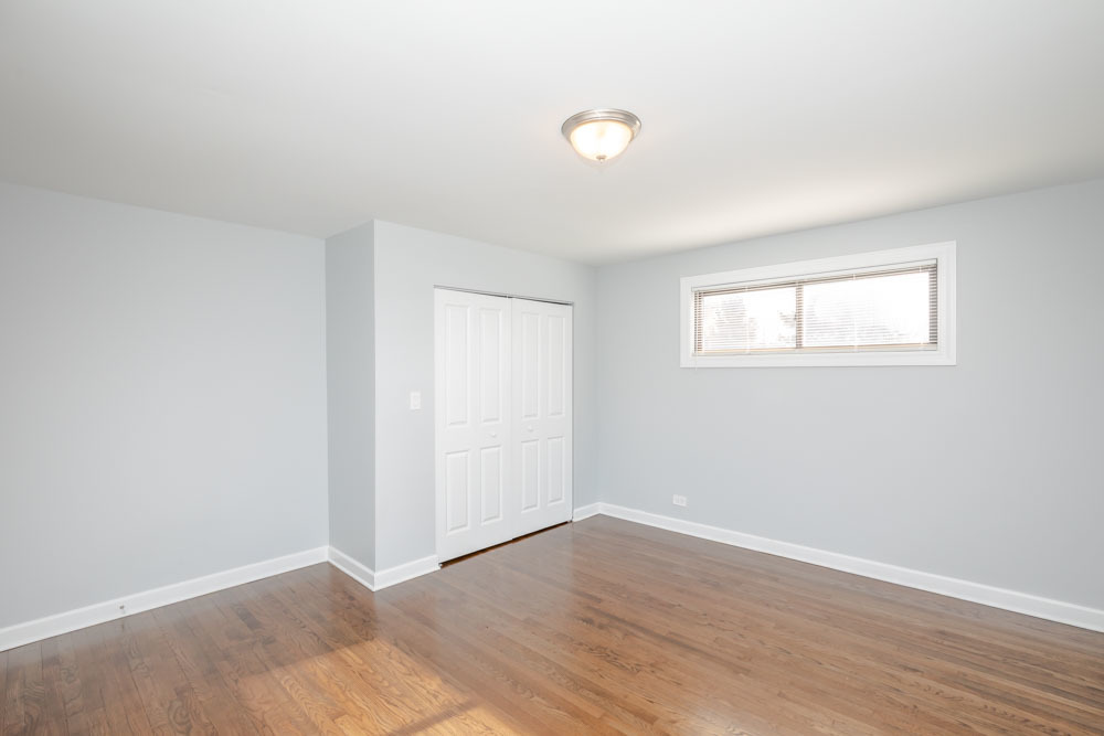 6807 North Ridge Boulevard, Unit 101 Chicago, IL 60645 - Photo 2 of 13 an empty room with wooden floor and windows
