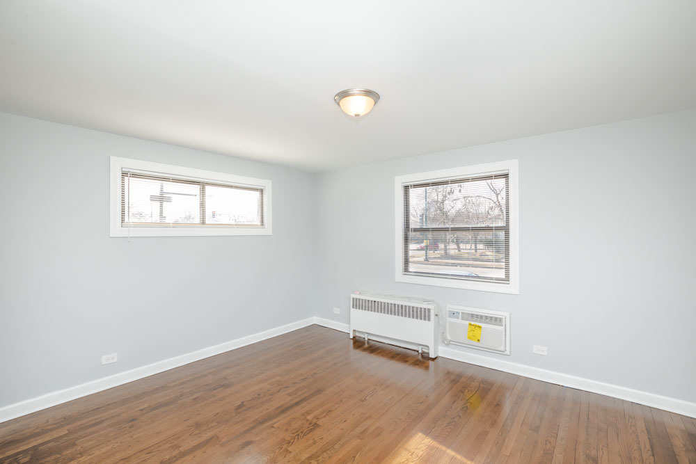 6807 North Ridge Boulevard, Unit 101 Chicago, IL 60645 - Photo 5 of 13 an empty room with wooden floor and windows