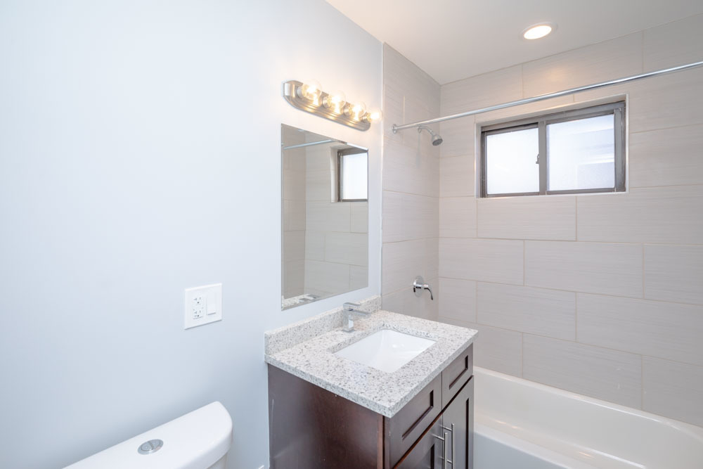 6807 North Ridge Boulevard, Unit 101 Chicago, IL 60645 - Photo 6 of 13 a bathroom with a sink a toilet and shower