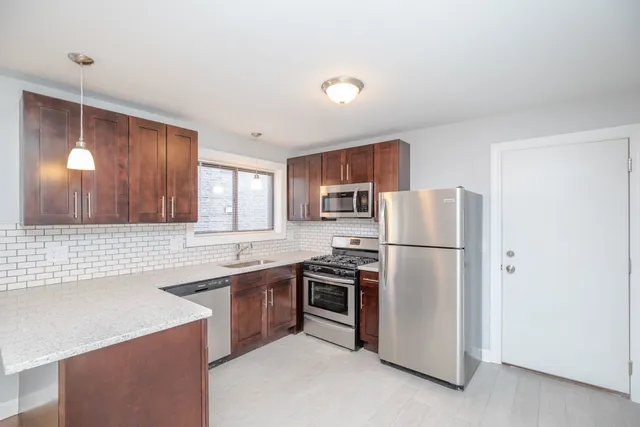 a kitchen with a sink a refrigerator a stove and cabinets
