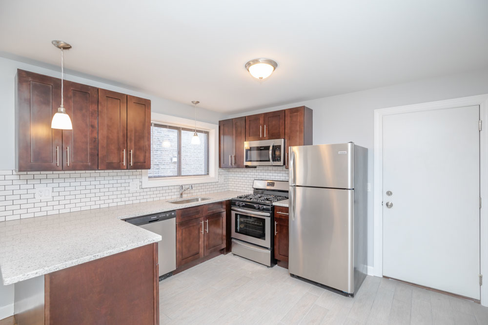 6807 North Ridge Boulevard, Unit 101 Chicago, IL 60645 - Photo 8 of 13 a kitchen with a sink a refrigerator a stove and cabinets