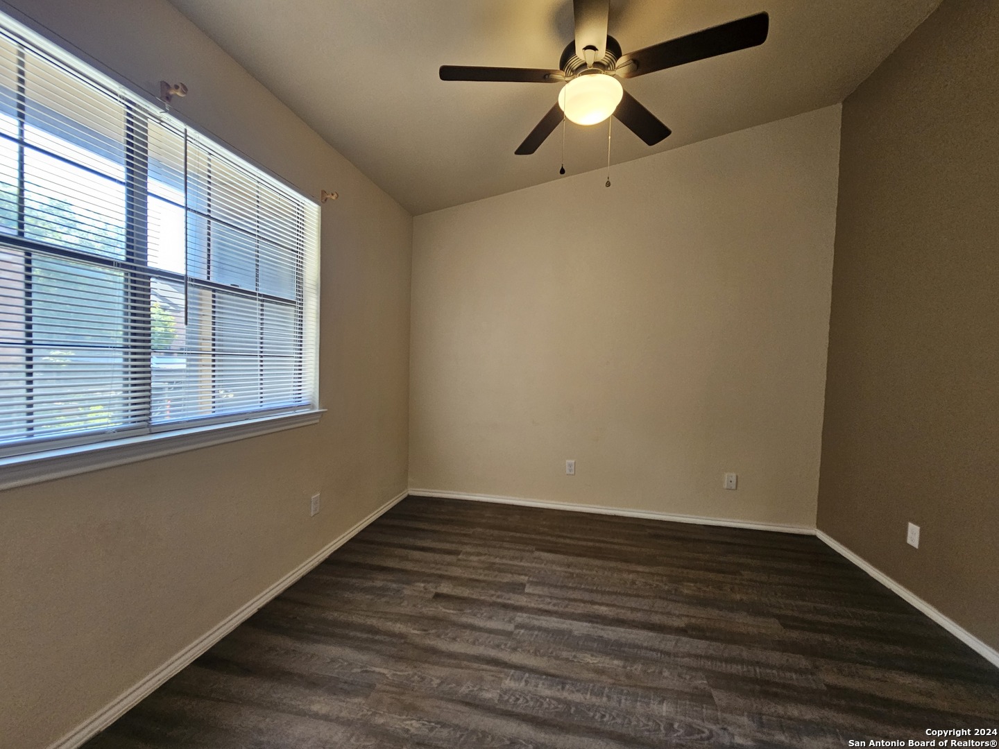 4803 Hamilton Wolfe Road, Unit 312 San Antonio, TX 78229 - Photo 11 of 13 a view of an empty room with wooden floor and a window