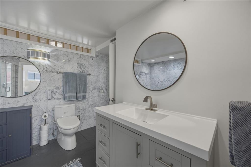 5535 Forbes Avenue, Unit E Pittsburgh, PA 15217 - Photo 18 of 50 a bathroom with a toilet a sink and a mirror