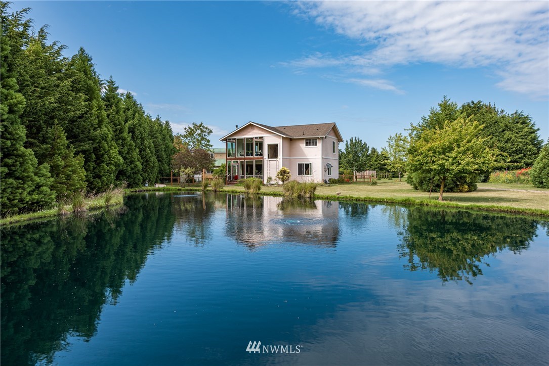 a view of a house with a yard and a pond