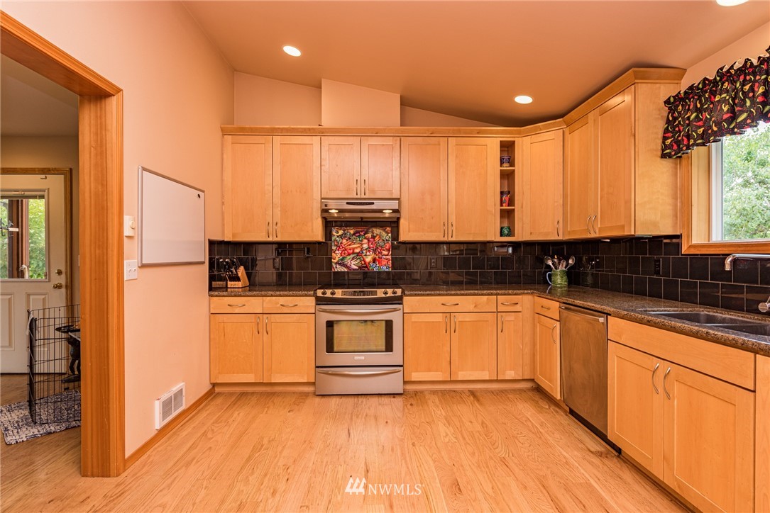 139 Buckhorn Road Sequim, WA 98382 - Photo 13 of 29 a kitchen with stainless steel appliances granite countertop a stove a sink and white cabinets