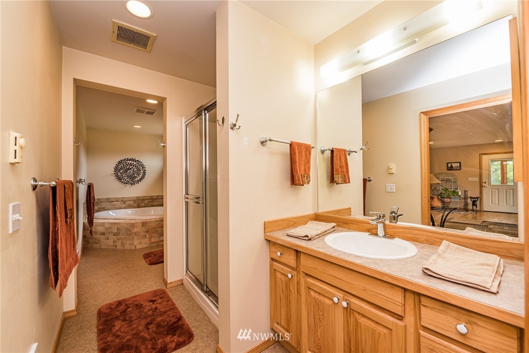139 Buckhorn Road Sequim, WA 98382 - Photo 22 of 29 a bathroom with a sink a mirror and a shower