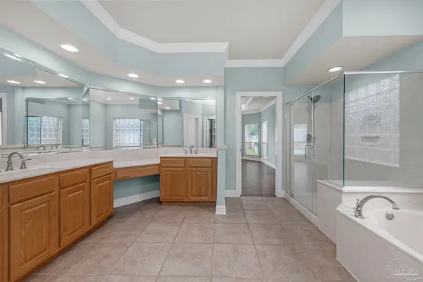 a bathroom with a tub a sink double vanity and a shower
