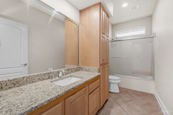 a bathroom with a granite countertop sink toilet and shower