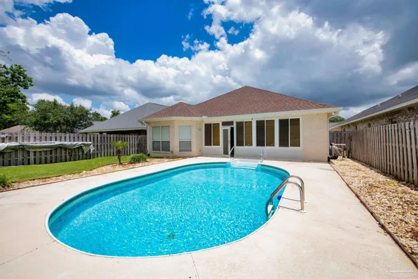 a view of a house with swimming pool and sitting area