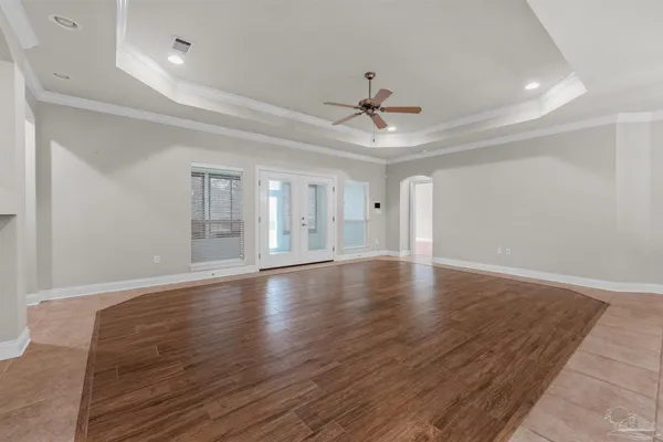 a view of a livingroom with wooden floor and a ceiling fan