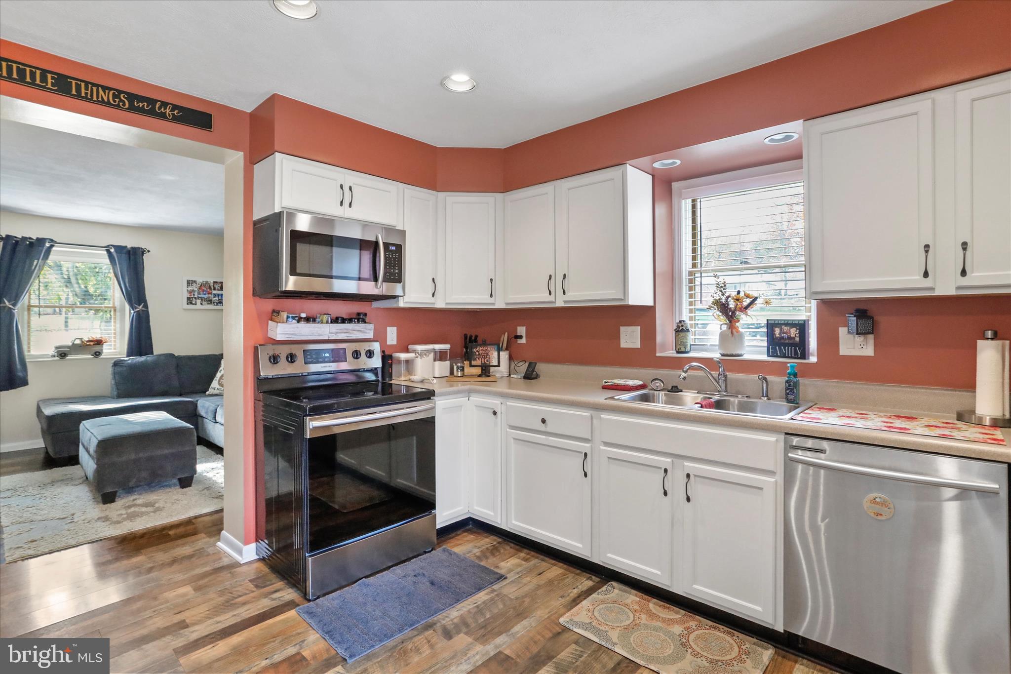 13719 Brant Road Southwest Cresaptown, MD 21502 - Photo 12 of 33 a kitchen with stainless steel appliances granite countertop a stove top oven a sink dishwasher and white cabinets with wooden floor