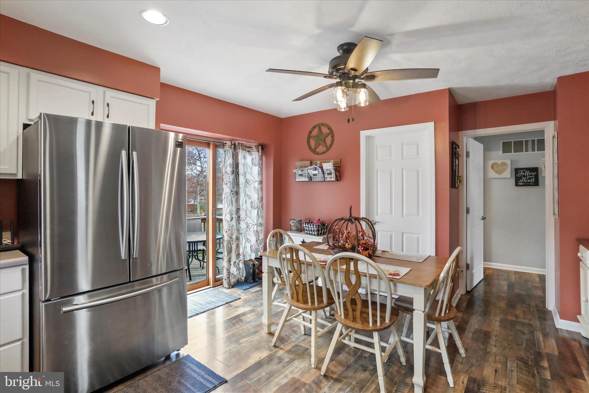 13719 Brant Road Southwest Cresaptown, MD 21502 - Photo 14 of 33 a kitchen with stainless steel appliances a refrigerator a microwave a dining table and chairs with wooden floor