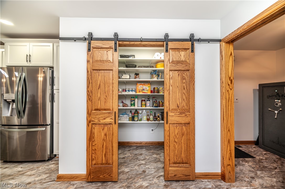 405 Airport Road Northwest Warren, OH 44481 - Photo 17 of 50 Custom pantry featuring wood-finish barn doors, integrated shelving, and ample storage