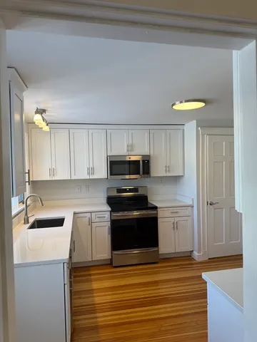 a kitchen with granite countertop a sink cabinets and stainless steel appliances