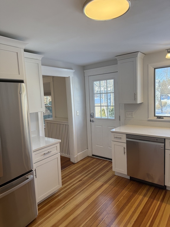 312 Edge Hill Road Milton, MA 02186 - Photo 4 of 13 a kitchen with stainless steel appliances granite countertop a refrigerator a sink dishwasher a stove and white countertops with wooden floor