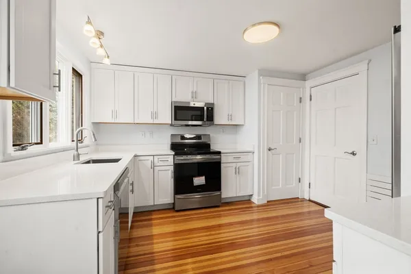 a kitchen with a sink cabinets and wooden floor