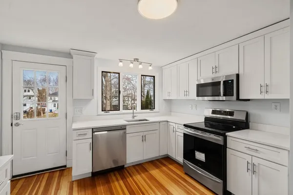 a kitchen with stainless steel appliances granite countertop a stove a sink and a microwave